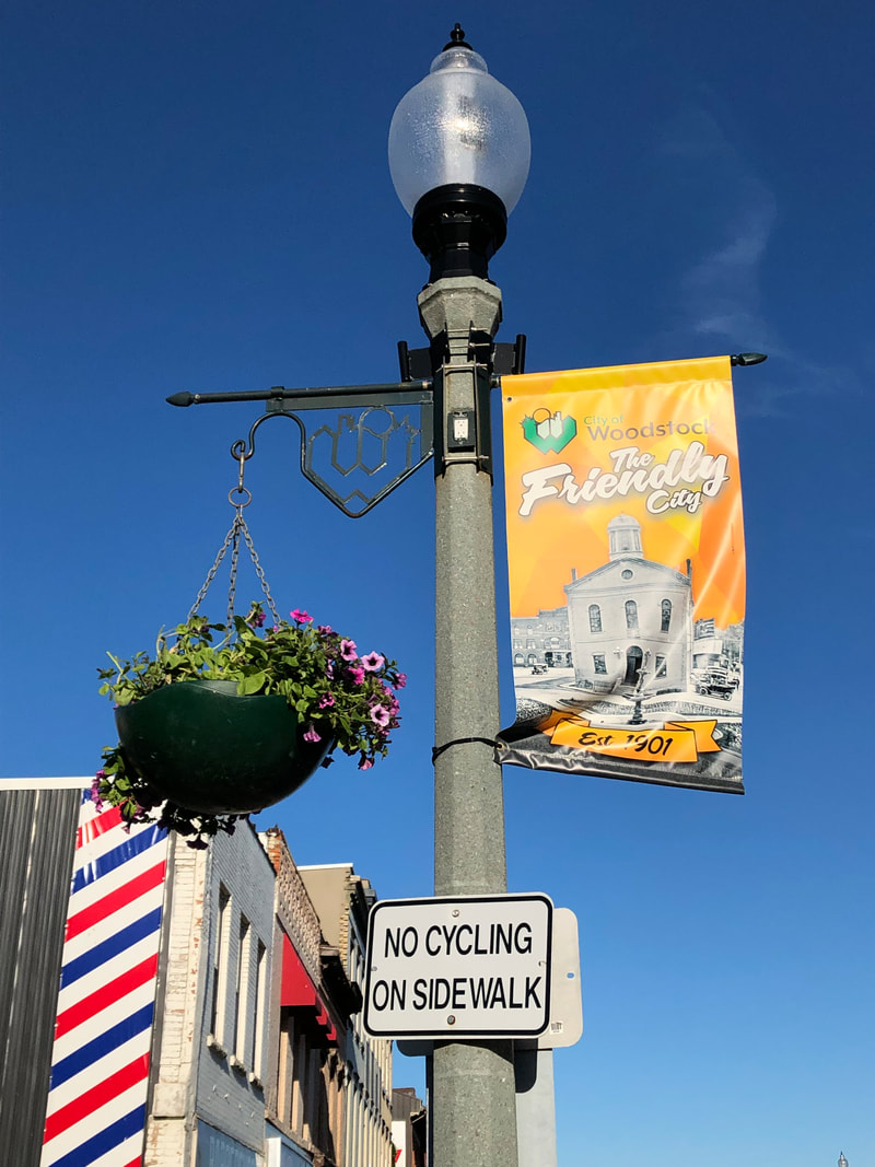 woodstock ontario welcome sign lightpost in front of prime barbershop woodstock on